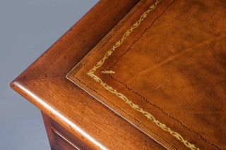 The gold tooling, brown leather, and mahogany look great together.